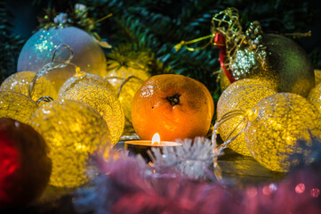 Fototapeta na wymiar Christmas decorations with tangerine and a candle