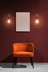 Orange velor armchair against a red wall and an empty picture	
