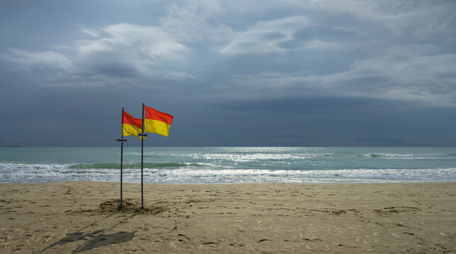 France, Aude, Port-la-Nouvelle, Warning flags on beach and storm clouds