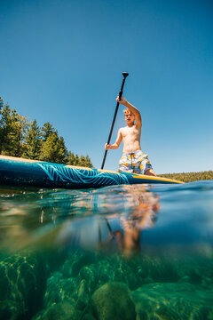 USA, California, Boy  paddleboarding on Lake Tahoe