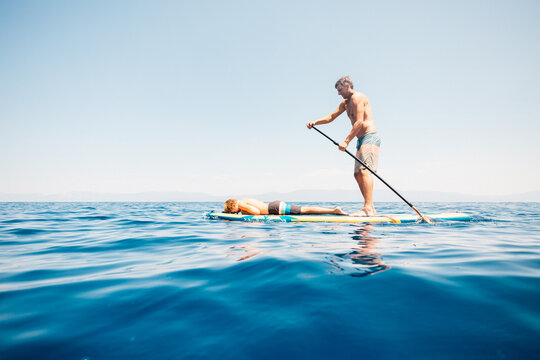 USA, California, Father and son paddleboarding on calm Lake Tahoe