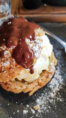 gros plan d'un profiterole avec un coulis de chocolat