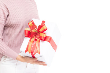 Female hands holding gift box wrapped with red ribbon isolated on white background with copy space. Woman hand holding gift box in christmas, new year, valentine day, birthday celebration concept.