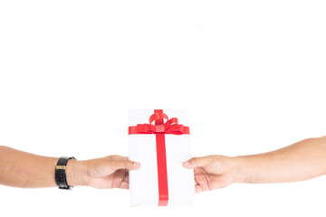 Male hands holding gift box wrapped with red ribbon isolated on white background with copy space. Man hand holding gift box giving in christmas, new year, valentine day, birthday celebration concept.