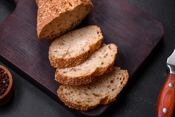 .Delicious crispy bread with cereals cut into slices on a wooden cutting board