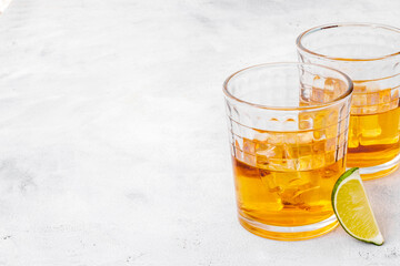 Glass of golden whiskey with ice. Strong alcoholic drink background