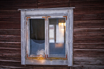Old window with broken glass. Red wooden building. Österbotten/Pohjanmaa, Finland