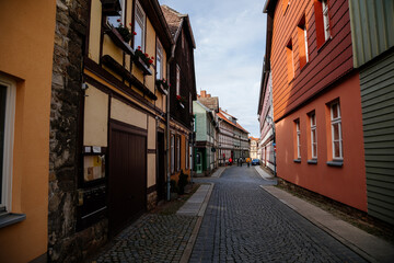 Wernigerode, Saxony-Anhalt, Germany, 29 October 2022: Historic old vintage colored timber frame houses in medieval town, UNESCO World Heritage city, half-timbered home at sunny autumn day, cobblestone