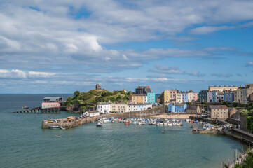 Fototapeta na wymiar Tenby harbour. A coastal resort in Pembrokeshire, south Wales. Colourful buildings overlook the harbour, on a sunny, summers day.