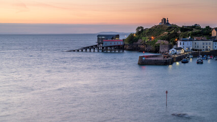 Obraz premium Tenby harbour and lifeboat station, at sunrise on a calm summers day.