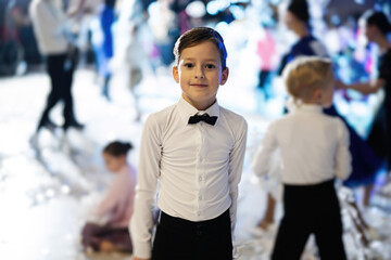 Boy in white shirt and bow tie, dance costume at children party.