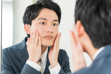 肌をチェックする若い日本人男性