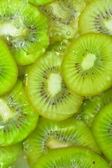 Close-up view of the green kiwi fruit slices in water background. Texture of cooling fruit drink with macro bubbles on the glass wall. Flat design. Vertical image