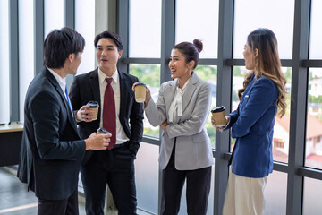 Business meeting of business people in office formal wear stand hold glass of coffee on break time