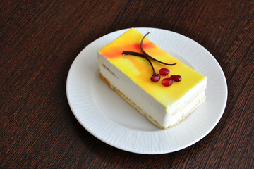 lemon tart isolated on white saucer, decorated with chocolate and pomegranate seeds, close-up