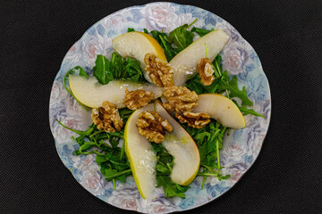 Top view of arugula salad and pears with walnuts