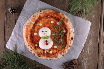 Mozzarella snowman on pizza with tomato base