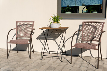 Chairs and table for relaxing outdoors on the terrace, veranda. Comfort relaxing zone. Cozy and comfortable atmosphere. Sunny day.
