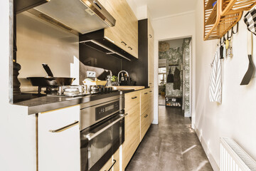 a kitchen with black and white tiles on the floor, wood paneled walls, and stainless steel...