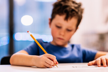 Boy sitting at table and drawing