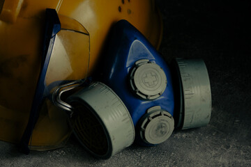 Respirator, goggles and miner protective helmet on concrete floor.
