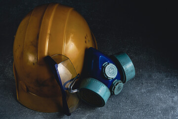 Respirator, goggles and miner protective helmet on concrete floor.