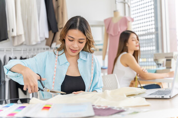 Two Asian women working together Small business, SME, tailoring designs for customers. Both of them acted as great designers.