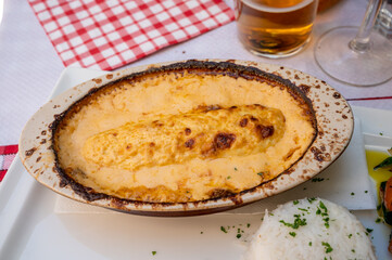 Quenelle, speciality of Lyon, oval-shaped dumplings filled with pike white fish served in creamy sauce in traditional Lyonnaise Bouchon, France