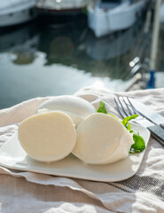 Tasting of white soft italian balls mozzarella cheese made from buffalo cow milk