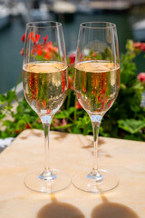 Drinking of French brut champagne sparkling wine in glasses in yacht harbour of Port Grimaud near Saint-Tropez, French Riviera vacation, France
