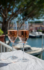 Drinking of French brut champagne sparkling wine in glasses in yacht harbour of Port Grimaud near Saint-Tropez, French Riviera vacation, France