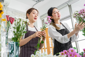 group of female florists Asians are arranging flowers for customers who come to order them for various ceremonies such as weddings, Valentine's Day or to give to loved ones.