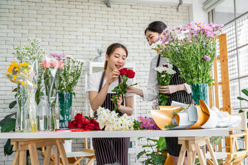 group of female florists Asians are arranging flowers for customers who come to order them for various ceremonies such as weddings, Valentine's Day or to give to loved ones.