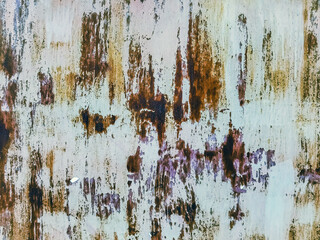 Close up to colored peeling paint texture on rusty metal surface. The old steel wall, painted and putty, peels off and collapses. Grunge background texture. Paint peel off in white color painted wall.