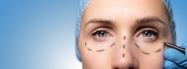 surgeon marking woman's face for cosmetic plastic surgery. facelift procedure. banner with copy...