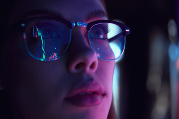 Close up view of girl's eyes in glasses looking at pc screen with computer reflection at eyewear....