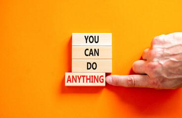 You can do anything symbol. Concept word You can do anything on wooden blocks. Businessman hand. Beautiful orange table orange background. Business and you can do anything concept. Copy space.
