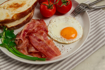 Breakfast, fried egg, bacon and bread, with cherry, on a light background, homemade, no people,