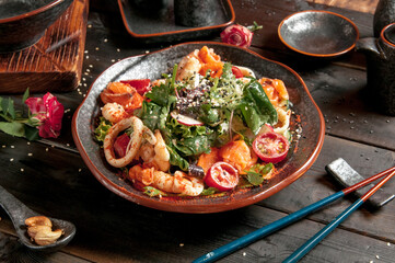 Seafood shrimp. Shrimp lettuce salad on white plate with lemon rosemary arugula on white wooden background. Healthy food or diet concept.