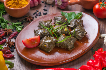 Dolma from grape leaves and minced on the wooden table