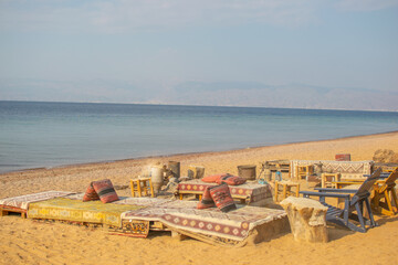 Traditional Authentic Colorful Bedouin Camp on the beach  with coffee pots and fire place, jars, cauldrons, on the sand at the Red Sea near Aqaba, Jordan, exotic relaxing travel tourism concept 