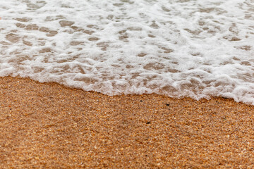 The seas are full on the sandy shore on a cloudy day. Rest on the sea. There is an empty space for text