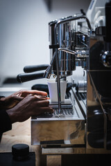 Hands of a black young man making coffee with an espresso machine