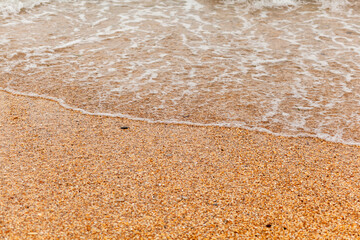 The seas are full on the sandy shore on a cloudy day. Rest on the sea. There is an empty space for text