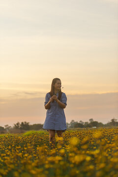 A beautiful girl is enjoying on the flower garden.The relaxation of the girl after hard work. , natural tourism.