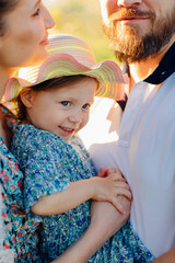 close-up. a mom and a dad with a baby daughter in a blooming spring garden.