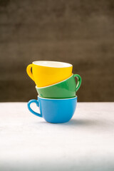 Colorful cups on wooden background