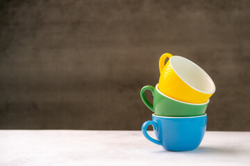 Colorful cups on wooden background