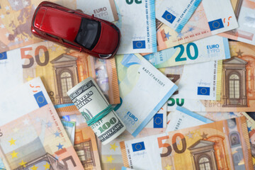 Money to buy or rent a car concept. Toy car with money cash