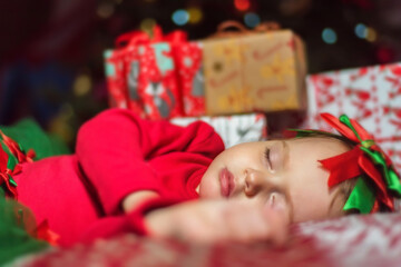 Obraz na płótnie Canvas Cute little baby girl sleeping near Christmas tree
